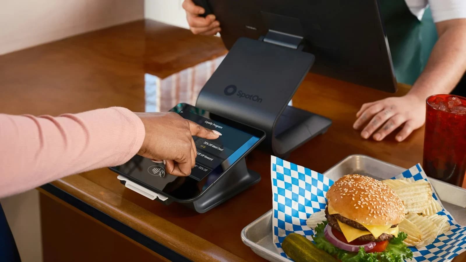 Restaurant owner analyzing food‑cost data on a tablet in a busy kitchen