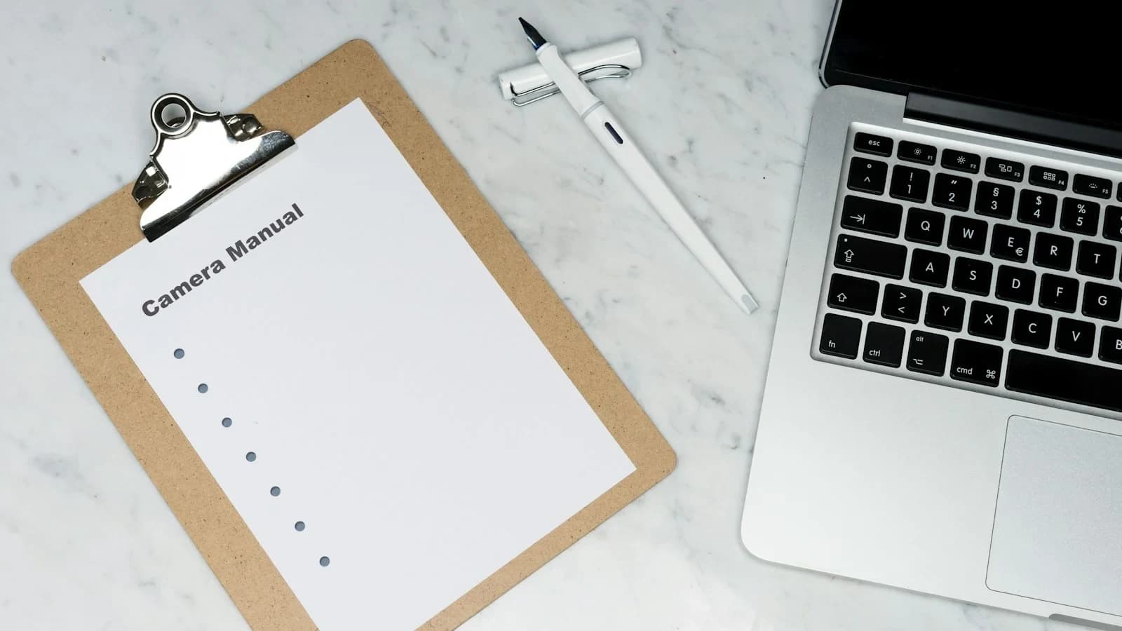 Small‑business owner reviewing a weekly job profitability checklist beside a laptop showing a QuickBooks report.